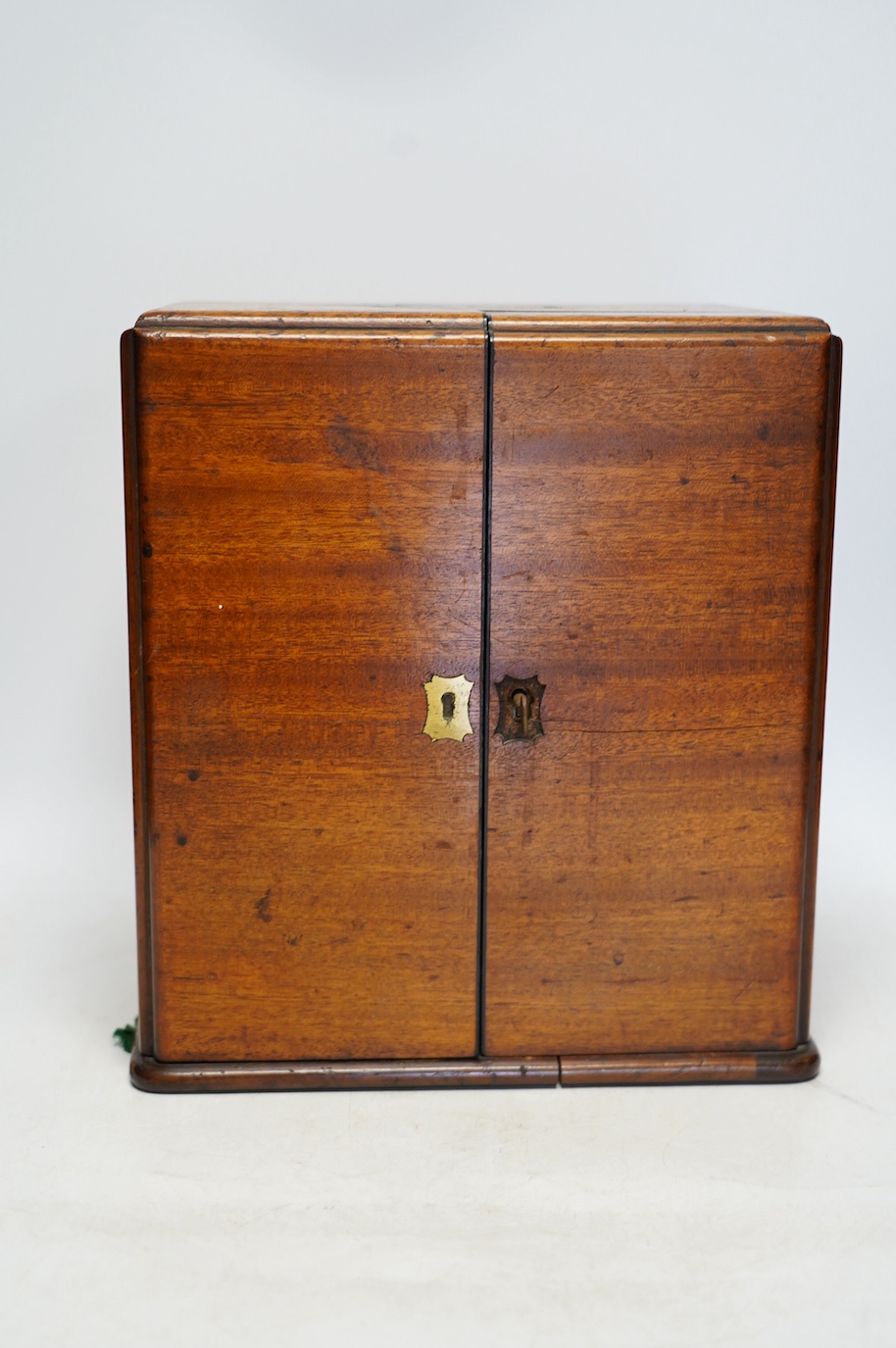 A late Victorian mahogany apothecary chest, containing a number of labelled glass bottles with preparations by James Woolley Sons and Co, Pharmaceutical Chemists, 28.5cm high, 25.5cm wide, 21cm deep. Condition - poor to